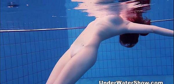  Redheaded cutie swimming nude in the pool